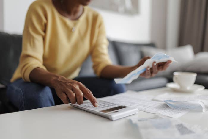 person using a calculator and looking at documents