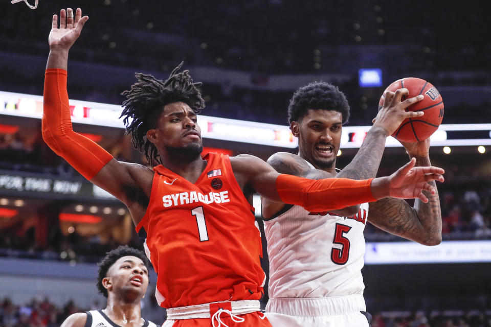 Louisville forward Malik Williams (5) grabs a rebound away from Syracuse forward Quincy Guerrier (1) during the second half of an NCAA college basketball game Wednesday, Feb. 19, 2020, in Louisville, Ky. Louisville won 90-66. (AP Photo/Wade Payne)
