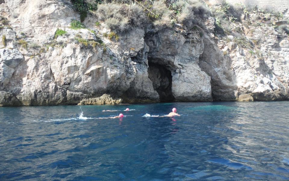 Swim along cliffs or front-crawl through rock arches and into pine-covered coves