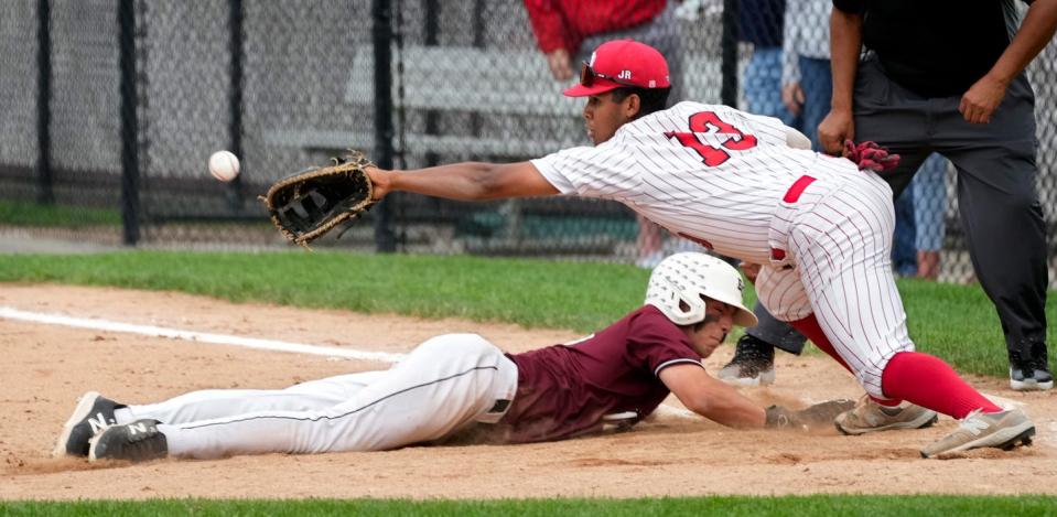 Cade Thomas dives back to the base in a game last season.