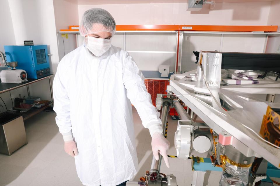 Ryan McCormick, JPL's principal investigator for COLDArm, stands next to a prototype of the robotic arm.