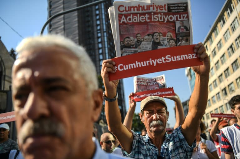 Journalists hold banners reading "Cumhuriyet won't be silenced" on a march to the courthouse this week