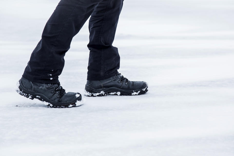 Man walking in winter day. Winter boots on legs. Active lifestyle at nature. Winter concept.