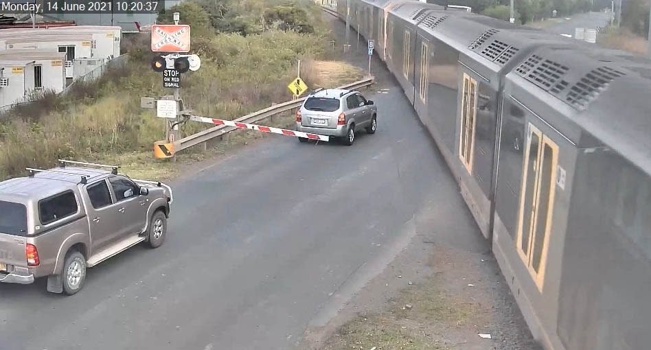 A screenshot of CCTV which captured a driver at Kembla Grange, who became trapped on the inside of a railroad crossing after they failed to slow down in time. Source: Transport for NSW