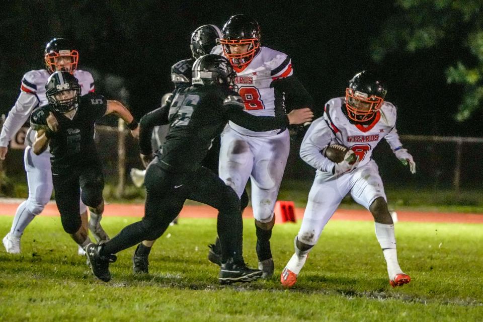 West Warwick's James Branch runs for a big gain before he's tackled by Pilgrim's Tristan Miller, center, during a game last September.