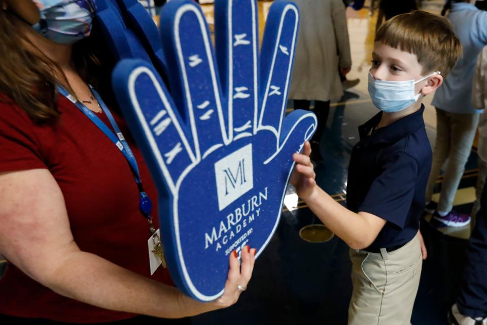 Matthew Fanning, 9, grabs a foam hand before the start of the pep rally as part of the annual Thanksgiving celebration and community service day at Marburn Academy in New Albany.