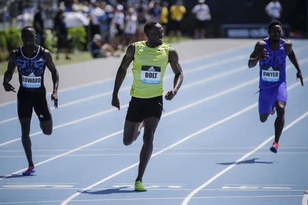 Usain Bolt (C) of Jamaica crosses the finish line to win the 200m at the IAAF Diamond League Grand Prix track and field competition in New York June 13, 2015. REUTERS/Eduardo Munoz