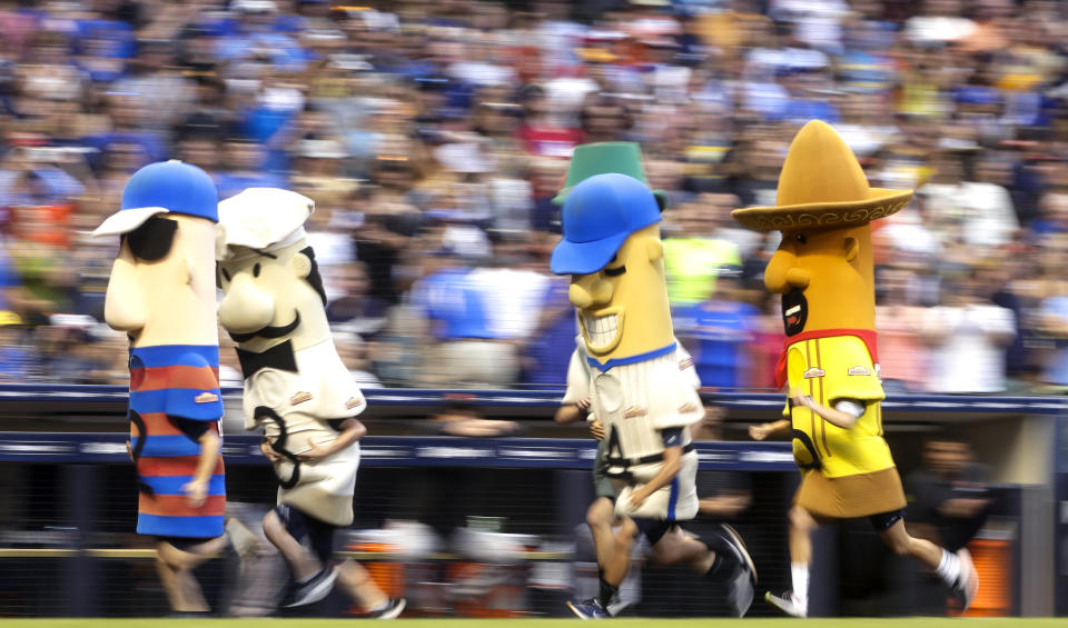 FILE - In this July 13, 2019, file photo, fans watch the racing sausages during a baseball game between the Milwaukee Brewers and the San Francisco Giants in Milwaukee. The chairman of the Wisconsin Republican Party, Andrew Hitt, is warning Milwaukee's chief elections official that it would be illegal for any Milwaukee Bucks or Brewers players or mascots to participate in early voting events planned at their stadiums in the days leading up to the election. Milwaukee plans to allow for in-person absentee voting at Miller Park and Fiserv Forum between Oct. 20 and Nov. 1. (AP Photo/Morry Gash, File)