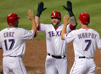 Mike Napoli is greeted by Rangers teammates Nelson Cruz and David Murphy after his three-run homer in Game 4