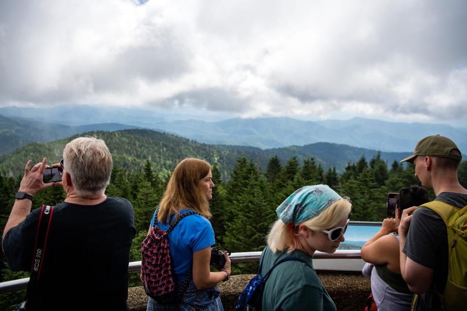 Visitors take photos in July while taking in a scenic view of the Smoky Mountains from the Clingmans Dome observational tower in the Great Smoky Mountains National Park.