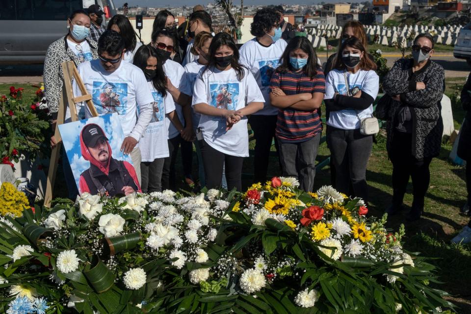 Relatives and friends of photojournalist Margarito Martínez mourn him during his burial at the Santa Gema cemetery in Tijuana, Baja California on Jan. 21, 2022.