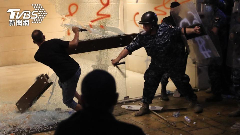 圖／達志影像美聯社，鎮暴軍警持警棍毆打驅離在官邸外牆塗鴉的抗議民眾。