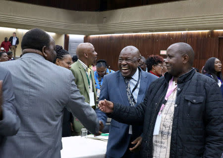 Zimbabwean War Veterans leader Chris Mutsvangwa (C) greets other delegates attending an extraordinary meeting of the ruling ZANU-PF party's central committee in Harare, Zimbabwe November 19, 2017. REUTERS/Philimon Bulawayo
