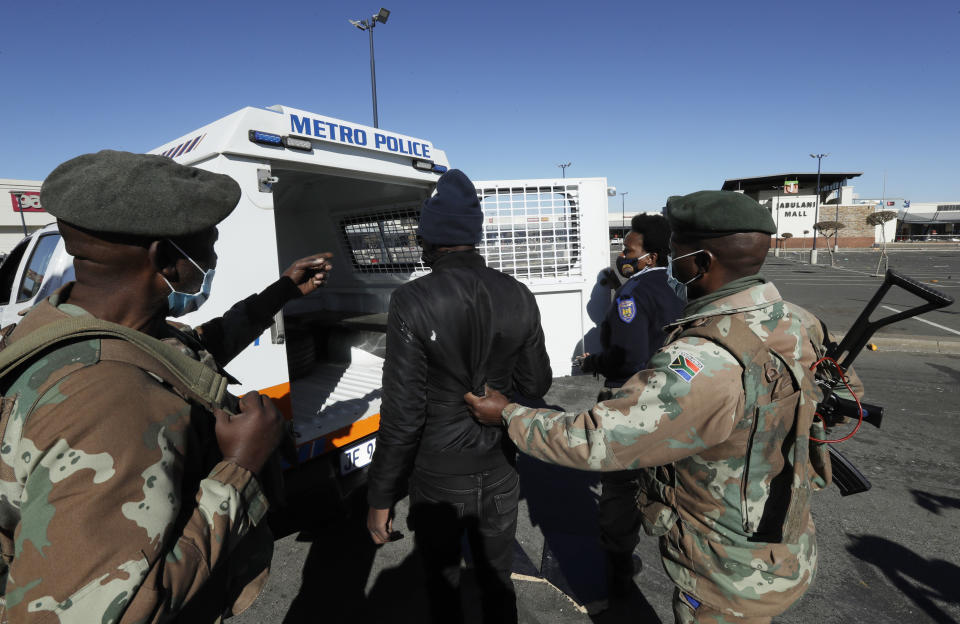 A man suspected of looting is arrested at a shopping mall in Soweto, near Johannesburg, Tuesday July 13, 2021. South Africa's rioting continued Tuesday as police and the military tried to halt the unrest in poor areas of two provinces, in Gauteng and KwaZulu-Natal, that began last week after the imprisonment of former President Jacob Zuma. (AP Photo/Themba Hadebe)