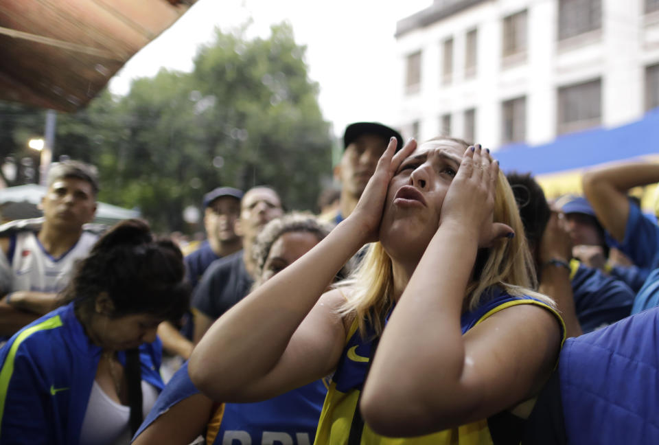 A Boca Juniors soccer fan reacts to losing 3-1 to River Plate as she watches on TV the Copa Libertadores final in Buenos Aires, Argentina, Sunday, Dec. 9, 2018. The South American decider was transferred from Buenos Aires to Madrid, Spain after River fans attacked Boca's bus on Nov. 10 ahead of the second leg. (AP Photo/Natacha Pisarenko)