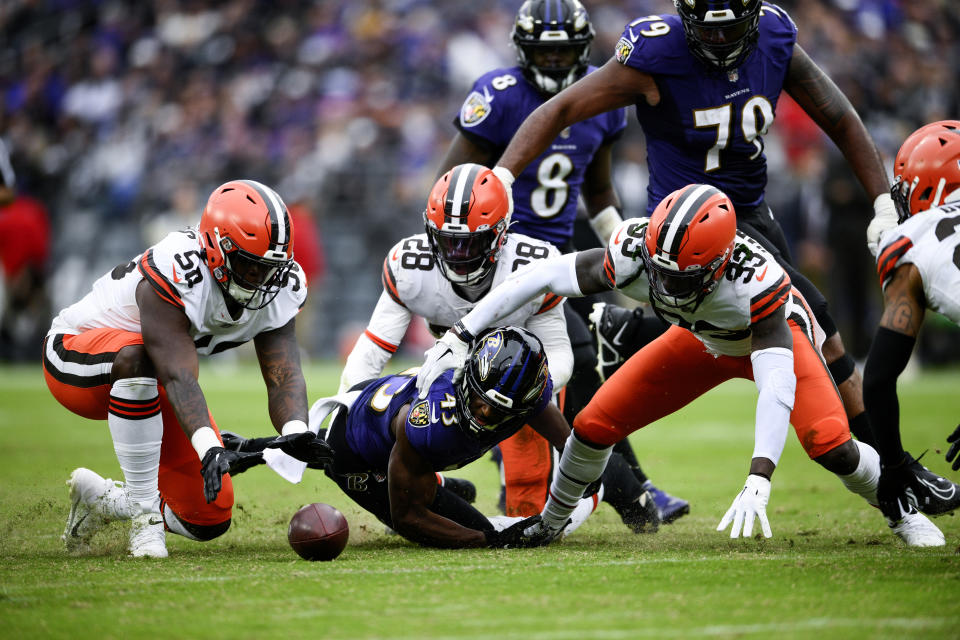 Cleveland Browns defensive end Isaiah Thomas (58) recovers Baltimore Ravens running back Justice Hill's (43) fumble infant of Cleveland Browns linebacker Jeremiah Owusu-Koramoah (28) and safety Ronnie Harrison Jr. (33) in the second half of an NFL football game, Sunday, Oct. 23, 2022, in Baltimore. (AP Photo/Nick Wass)