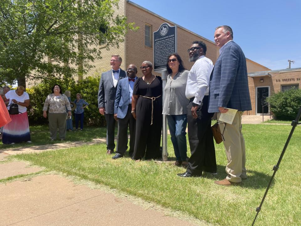 Members of the church and Lubbock County officials pose in front of the new historical marker.