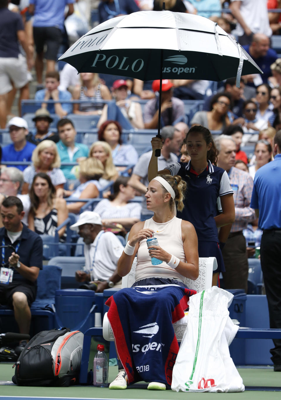 Victoria Azarenka, of Belarus, sits under and umbrella as the roof is closed during the third round of the U.S. Open tennis tournament against Sloane Stephens, Friday, Aug. 31, 2018, in New York. (AP Photo/Jason DeCrow)
