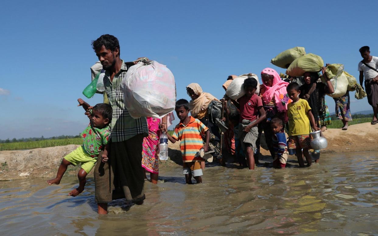 Rohingya refugees walk towards a refugee camp after crossing the border in Anjuman Para near Cox's Bazar - REUTERS