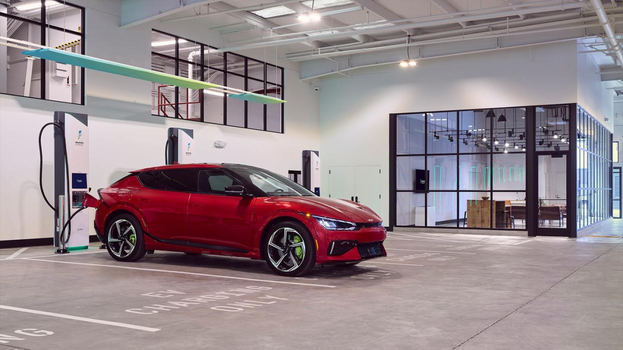 a red car charging in a large room with glass walls