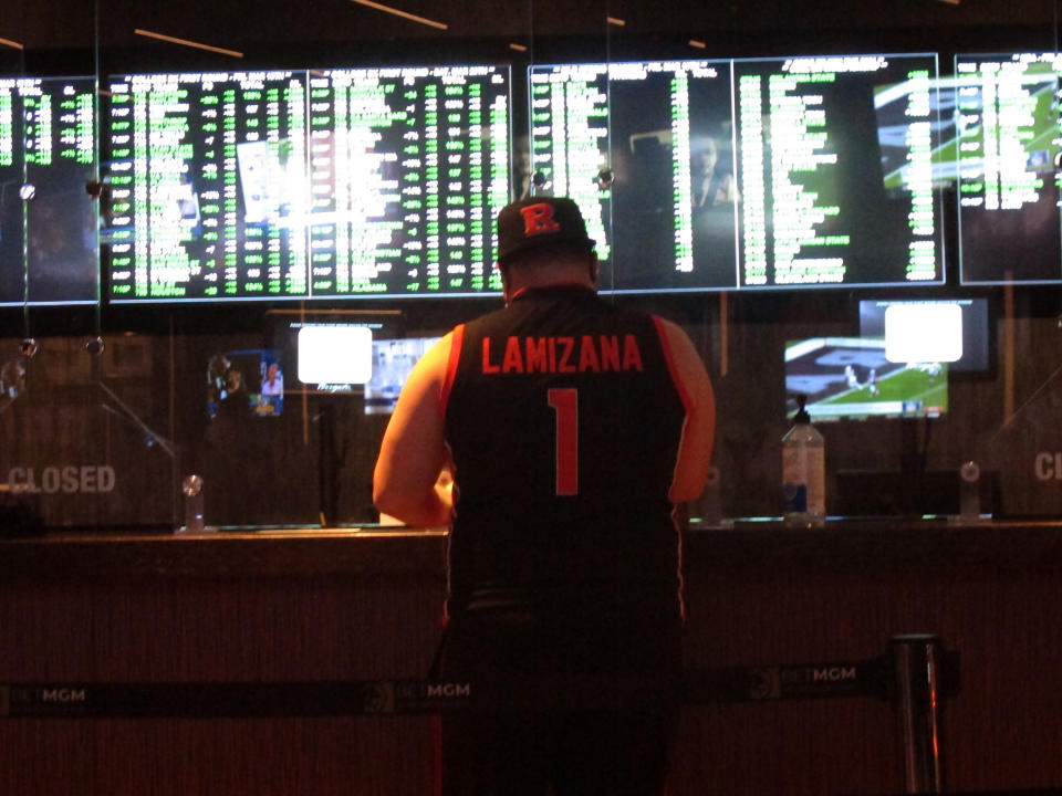 FILE - In this Friday, March 19, 2021, file photo, a man makes a sports bet at the Borgata casino in Atlantic City, N.J. On Wednesday, Oct. 20, 2021, the NFL announced it is spending $6.2 million on a responsible betting program with the National Council on Problem Gambling to teach people how to bet on sports responsibly and to fund and expand treatment and prevention programs for compulsive gambling.(AP Photo/Wayne Parry, File)