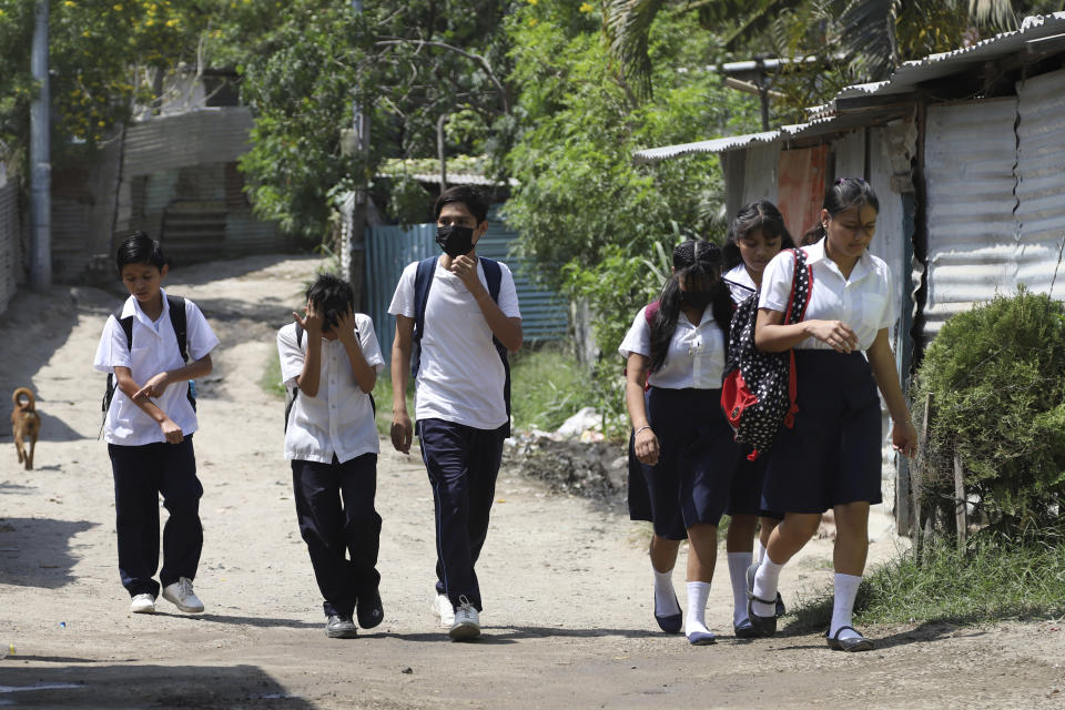 Students walk in the Primero de Diciembre neighborhood of Soyapango, El Salvador, Thursday, March 2, 2023. The area was considered a red zone until the government's "state of exception" came into effect in March 2023 and police stormed the neighborhood to arrest alleged gang members. Nearly one in six people who have been imprisoned are innocent, estimates the country’s police union tracking detentions and Human Rights Watch estimates that more than 1,000 children have been detained. (AP Photo/Salvador Melendez)