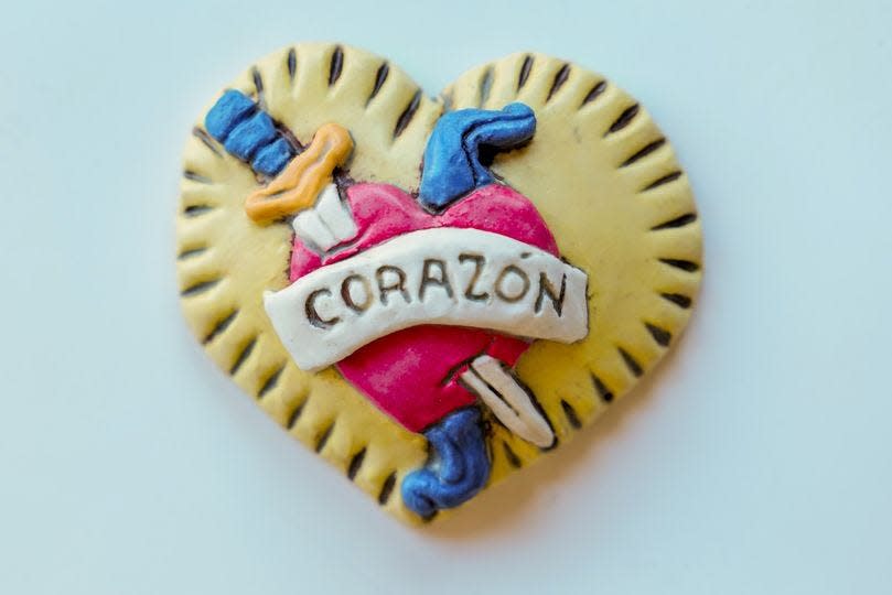 The medallion is designed to mimic the logo for Café Corazon, a sponsor for the treasure hunt. The heart-shaped item is approximately 3 inches in diameter.