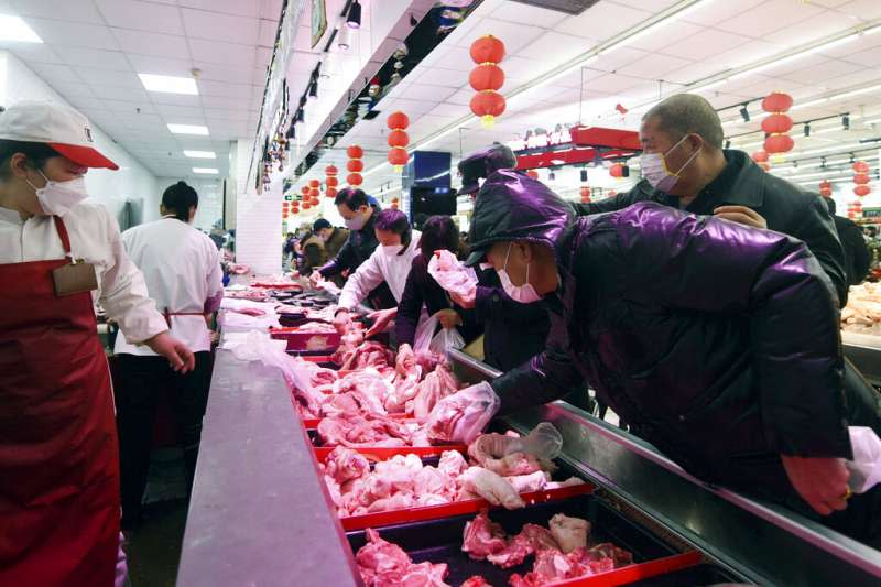 武漢肺炎肆虐，浙江杭州一間超市擠滿了戴著口罩前來搶購食物的民眾。（美聯社）