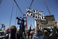 A man speaks into a megaphone while standing with others on the center divider as traffic is stopped on the Golden Gate Bridge in San Francisco, Saturday, June 6, 2020, at a protest over the death of George Floyd. Floyd died May 25 after being restrained by Minneapolis police. (AP Photo/Jeff Chiu)