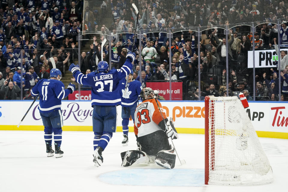 Toronto Maple Leafs defenseman Timothy Liljegren (37) celebrates after William Nylander (88) scored on Philadelphia Flyers goaltender Samuel Ersson (33) during overtime in an NHL hockey game Thursday, Feb. 15, 2024, in Toronto. (Arlyn McAdorey/The Canadian Press via AP)