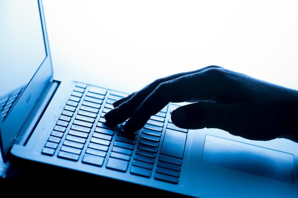 A woman’s hand presses a key of a laptop keyboard. (PA Archive)