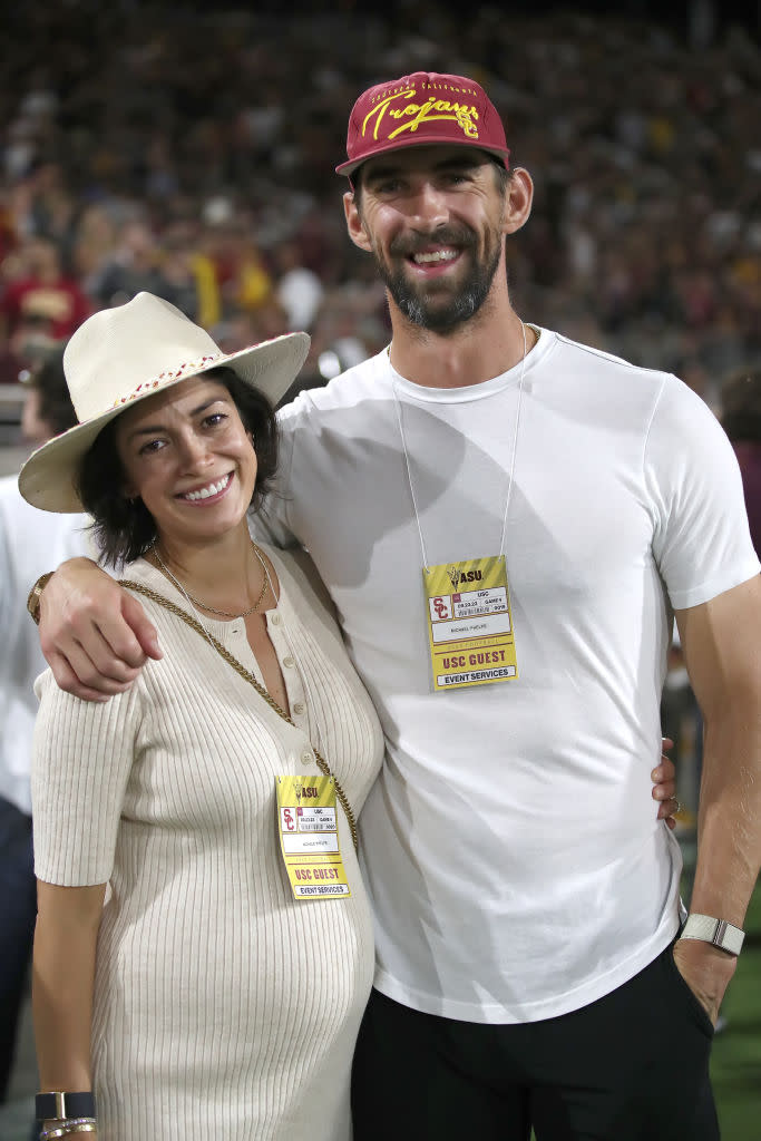 TEMPE, ARIZONA - SEPTEMBER 23: Michael Phelps and his wife Nicole Phelps, an USC graduate, pose for a photo on the USC sidelines during the Arizona State Sun Devils versus the University of Southern California Trojans football game at Mountain America Stadium on September 23, 2023 in Tempe, Arizona. (Photo by Bruce Yeung/Getty Images)