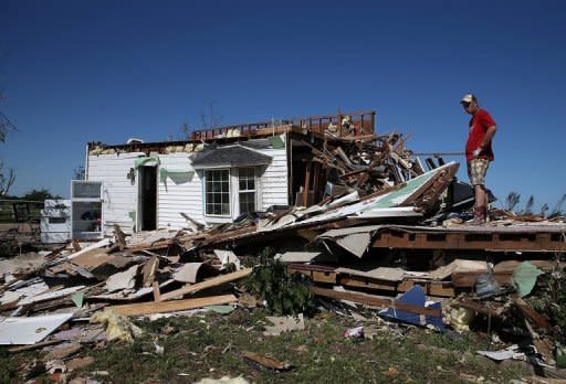 A man sifts looks at his damaged home after a series of tornadoes June 1, 2013 in El Reno, Oklahoma. Three veteran storm chasers were killed while pursuing powerful tornadoes that tore through the US state of Oklahoma, a relative said