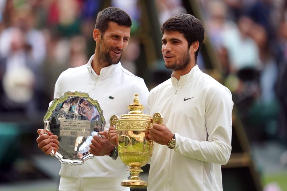 Carlos Alcaraz with the trophy, alongside Novak Djokovic (PA Wire)