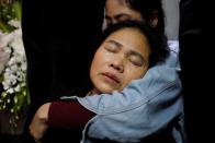 Anna Hoang Thi Ai, madre de John Hoang Van Tiep, víctima que fue encontrada muerta en la parte trasera de un camión británico el mes pasado, llora junto a su cuerpo en la provincia de Nghe An