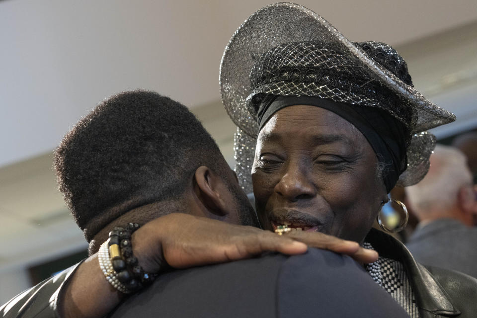 Marian Markelo, a Winti Priest, an Afro-Surinamese traditional religion, right, is hugged after Dutch Prime Minister Mark Rutte apologized on behalf of his government for the Netherlands' historical role in slavery and the slave trade at the National Archives in The Hague, Monday, Dec. 19, 2022. Rutte made the apology came despite some activist groups urging him to wait until next year to apologize on the July 1 anniversary of the country's abolition of slavery. (AP Photo/Peter Dejong)