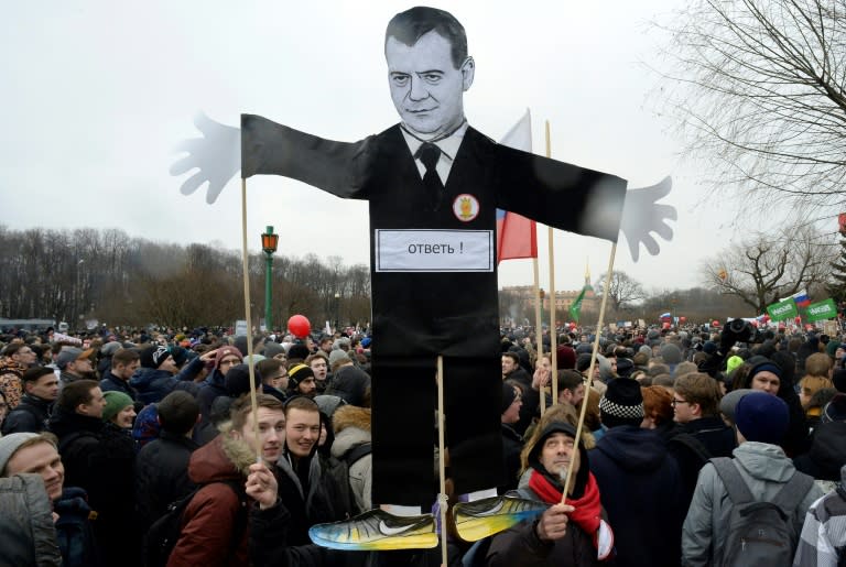 Opposition supporters with a cutout figure depicting Prime Minister Dmitry Medvedev participate in an anti-corruption rally in central Saint Petersburg on March 26, 2017