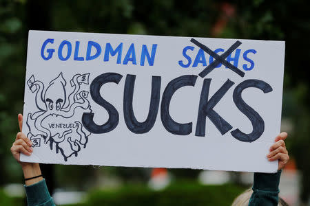 A protester holds a sign as she demonstrates outside of Goldman Sachs headquarters after the company purchased Venezuelan bonds in New York, U.S., May 30, 2017. REUTERS/Lucas Jackson