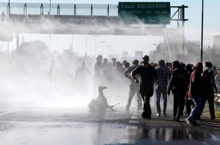 Protestors are sprayed with water by Argentine police as they block a road during a 24-hour national strike in Buenos Aires, Argentina, April 6, 2017. REUTERS/Martin Acosta