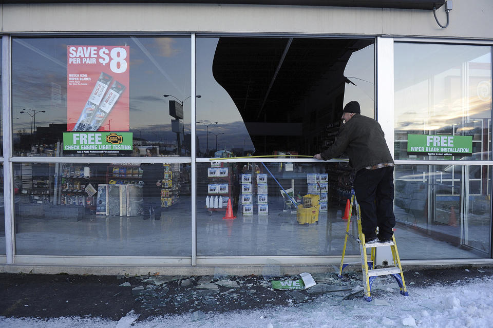 FILE - In this Nov. 30, 2018, file photo, Dennis Keeling, of Instant Services, measures for a broken window at an auto parts store following an earthquake in Anchorage, Alaska Seven weeks after the massive earthquake struck Alaska, the seemingly endless aftershocks are keeping many residents filled with anxiety. (AP Photo/Mike Dinneen, file)