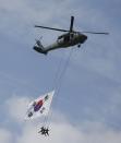 Members of the Special Warfare Command hang suspended from an army helicopter during celebrations to mark the 65th anniversary of Korea Armed Forces Day, at a military airport in Seongnam, south of Seoul, October 1, 2013. (REUTERS/Kim Hong-Ji)