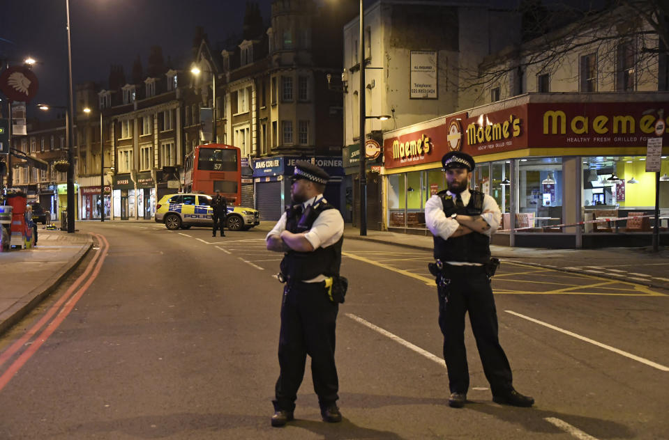 Police officers stand guard near the scene after a stabbing incident in Streatham London, England, Sunday, Feb. 2, 2020. London police officers shot and killed a suspect after at least two people were stabbed Sunday in what authorities are investigating as a terror attack. (AP Photo/Alberto Pezzali)