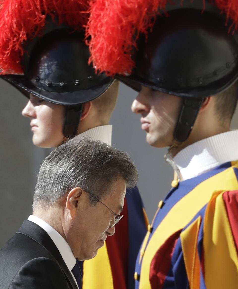 RECROP - South Korean President Moon Jae-in walks between two Vatican Swiss Guards as he enters the building ahead of his private audience with Pope Francis, at the Vatican, Thursday, Oct. 18, 2018. South Korea's president is in Italy for a series of meetings that will culminate with an audience with Pope Francis at which he's expected to extend an invitation from North Korean leader Kim Jong Un to visit. (AP Photo/Andrew Medichini)