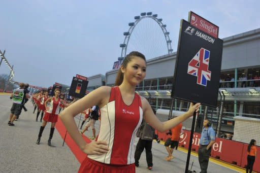 Unas azafatas toman posiciones para el desfile de pilotos previo a la disputa del Gran Premio de Fórmula 1 de Singapur este domingo 23 de septiembre de 2012. (AFP | Romeo Gacad)