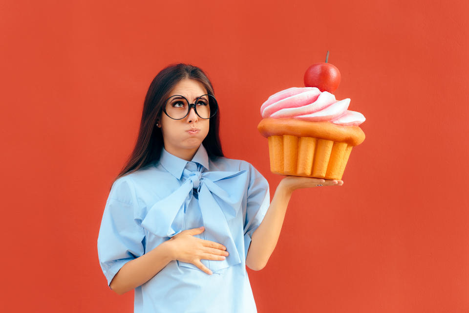 Hungry overeating girl binge eating indulging on sweets