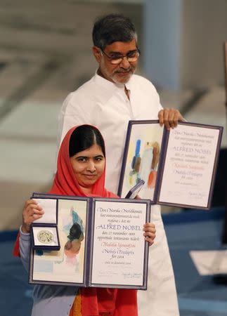 Nobel Peace Prize laureates Malala Yousafzai (front) and Kailash Satyarthi pose with their medal and diploma during the Nobel Peace Prize awards ceremony at the City Hall in Oslo December 10, 2014. REUTERS/Suzanne Plunkett