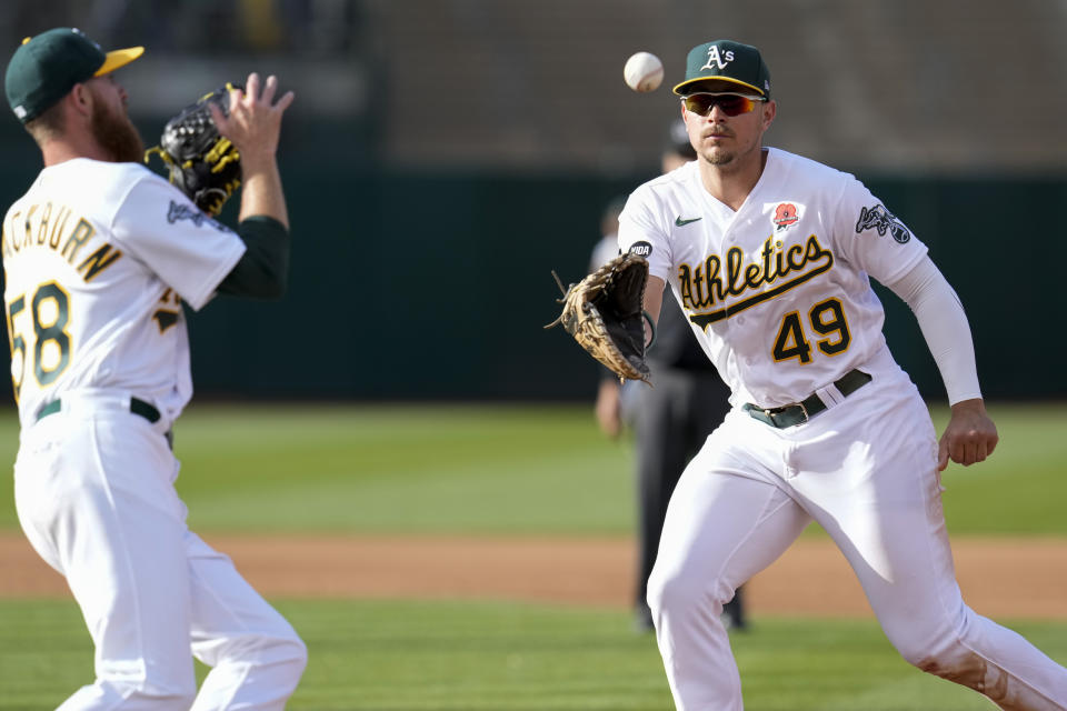 Oakland Athletics first baseman Ryan Noda, right, tosses the ball to pitcher Paul Blackburn, left, for an out on Atlanta Braves' Michael Harris II during the fourth inning of a baseball game in Oakland, Calif., Monday, May 29, 2023. (AP Photo/Godofredo A. Vásquez)