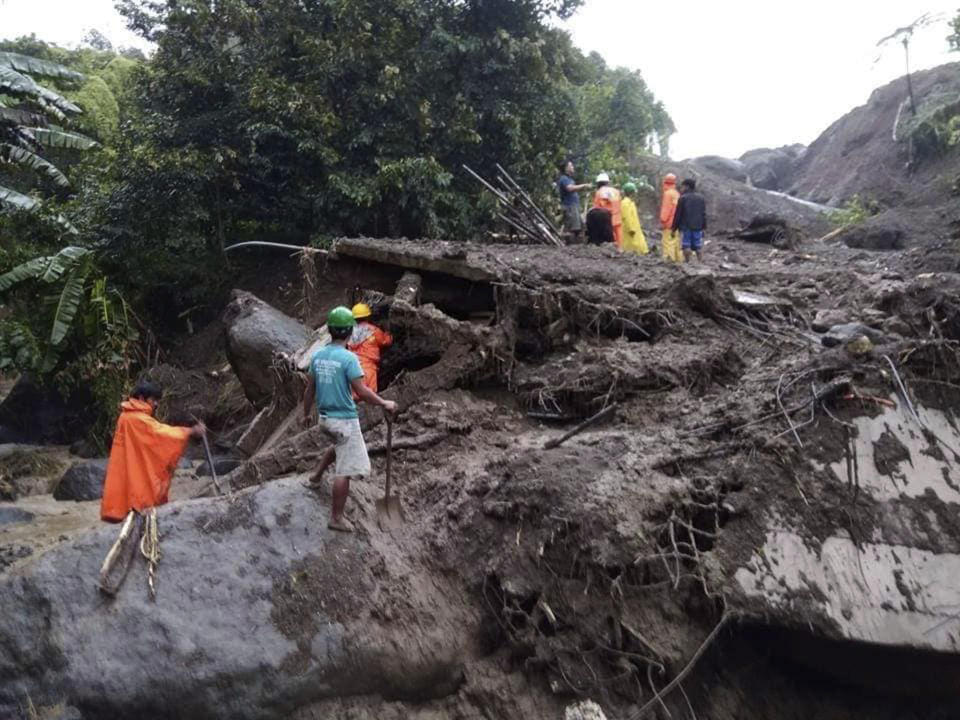 In this image provided by the Department of Public Works and Highways, Mountain Province District Engineering Office, rescuers dig through the earth to search for survivors after a massive landslide in Natonin township, Mountain Province in northern Philippines Wednesday, Oct. 31, 2018. A massive landslide set off by a typhoon crashed down on two government buildings in a northern Philippine mountain province, officials said Wednesday. (DPWH MPDSEO via AP)