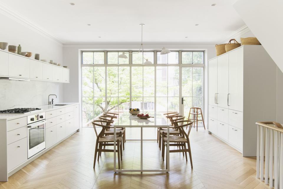 "The kitchen cabinets were custom and we spent a lot of time thinking about how they would be viewed from all angles," says Roberts. Embedded directly into the wall, the marble backsplash doesn't bump out clumsily from the wall and the cabinets on the right side were built to resemble a tall armoire. In the middle, Gould paired Hans J. Wegner wishbone chairs with a slim Blu Dot table. "The curves of the chairs just work so well with the angularity of the table," she says. Above hangs a white metal light fixture by Lambert & Fils.