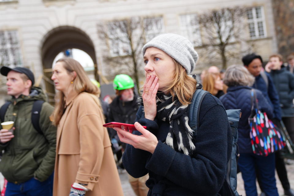 People react to a fire as the Old Stock Exchange building burns in Copenhagen, Denmark, Tuesday, April 16, 2024. A fire raged through one of Copenhagen’s oldest buildings on Tuesday, causing the collapse of the iconic spire of the 17th-century Old Stock Exchange as passersby rushed to help emergency services save priceless paintings and other valuables. (Ida Marie Odgaard/Ritzau Scanpix via AP)